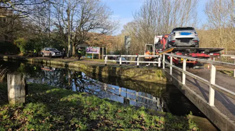BBC/Aisha Iqbal A bridge over the Leeds-Liverpool Canal near Saltaire. A truck on the bridge has a silver Range Rover on its flatbed