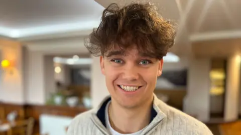 A man with brown hair, smiling