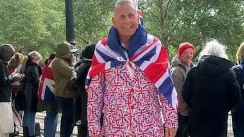 A man wears a suit patterned with the union jack