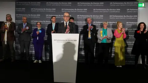 Reuters All party candidates line up behind the council executive at the lectern as they all applaud members of the crowd and workers