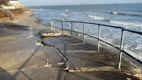 Isle of Wight Council Seaview slipway, viewed from the top end towards the stony beach at low tide, is criss-crossed by large cracks