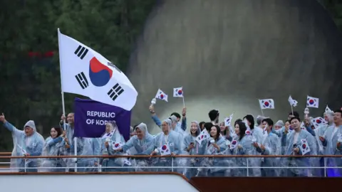 Reuters Paris 2024 Olympics - Opening Ceremony - Paris, France - July 26, 2024. Athletes of South Korea aboard a boat in the floating parade on the river Seine during the opening ceremony