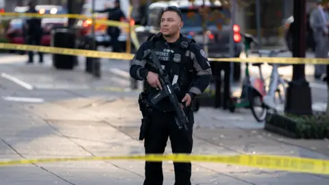Reuters A member of the US Secret Service stands guard while holding a gun in a cordoned-off area near the White House in Washington, DC on Wednesday.