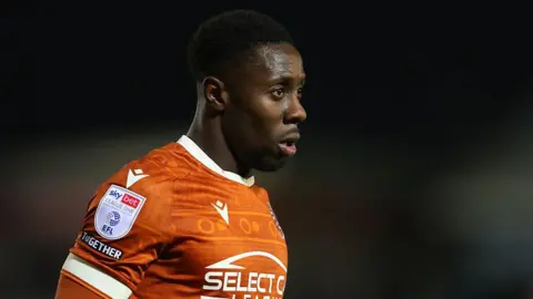 Andy Yiadom looks on while in action for Reading, in his orange shirt