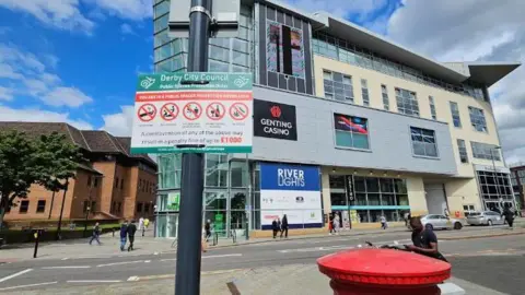 Derby City Council A sign in Derby City Centre which tells people about their Public Space Protection Order in front of Genting Casino. The sign says you can be fined up to £1,000 for a number of offences including drinking alcohol in public.