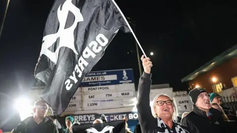 A supporter waves an Ospreys flag