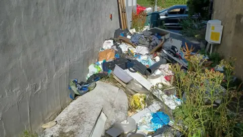 Bradford Council Waste in Ms Munir's garden