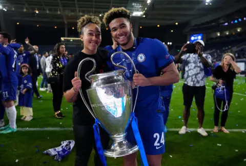 Getty Images Reece James, with his sister Lauren James, as the pair hold the Champion's League trophy during on-pitch celebrations