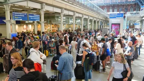 PA Media Crowds in a snaking queue at St Pancras international train stration.