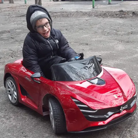 Tetiana Prudnykova Mikhailo in a red play car