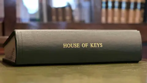 A green leather bound book with House of Keys on the spine.