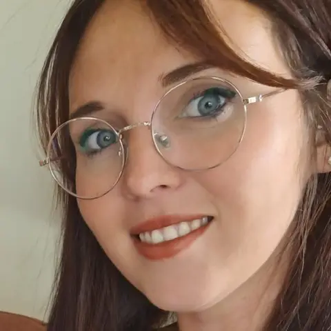 Lucy Greenstreet Lucy Greenstreet. She has long brown hair and thin framed large glasses. 