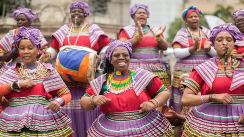 Women from Afrana in the traditional Pasoto multi -colored clothes singing and dancing 