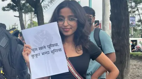 Tanuja Pandey Tanuja Pandey cầm tờ giấy có khẩu hiệu chống tham nhũng trong cuộc biểu tình của thế hệ Z ở Nepal