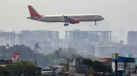 Shutterstock Mandatory Credit: Photo by DIVYAKANT SOLANKI/EPA-EFE/REX/Shutterstock (13778288a)An Air India passenger prepares to land at Chhatrapati Shivaji International Airport in Mumbai, India 22 February 2023. According to Tata group, which fully owns Air India, the merger process with Vistara Airline, a joint venture between Tata Sons and Singapore Airlines, is estimated to be completed by March 2024.Air India to begin merging process with Vistara, Mumbai - 22 Feb 2023