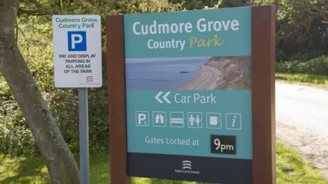 Getty Images Entry sign for Cudmore Grove Country park. It advertises facilities such as parking, toilets and a cafe.