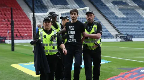 REUTERS The protester being removed from the pitch by police