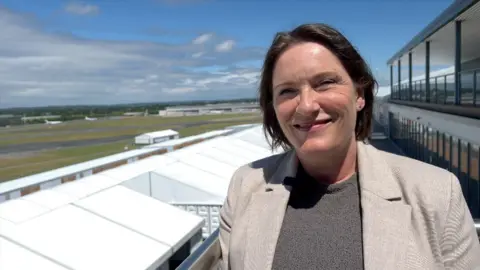 Farnborough International Exhibition & Conference Centre director Sarah Marshall smiling outside during an interview. It is sunny.