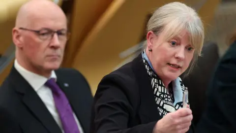 Shona Robison and First Minister John Swinney at the Scottish Parliament.