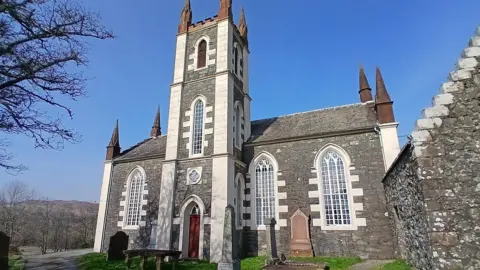 Richard Law An impressive granite church with white features and some gravestones in front of it