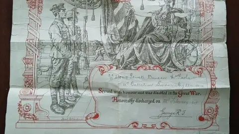 MacFarlane family A white letter with red scroll and military scene details, displaying a block of text in the lower right corner addressed ro Private Duncan MacFarlane, 4th battalion Gordon Highlanders