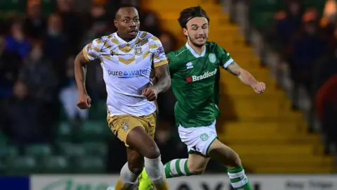 Munashe Sundire (left) running with the ball during a match for Tamworth