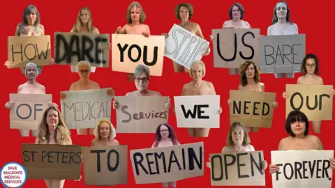 Save Maldon's Medical Services Naked women hold up signs reading: 'How dare you strip us bare of medical services, we need our St Peter's to remain open forever'