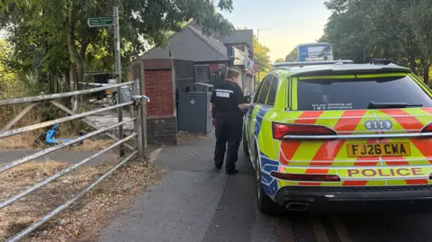 A police officer next to a police car