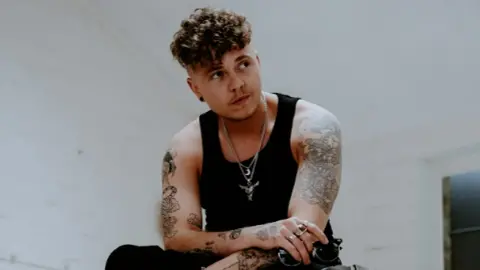 Dylan Holloway A press shot of a man all in black