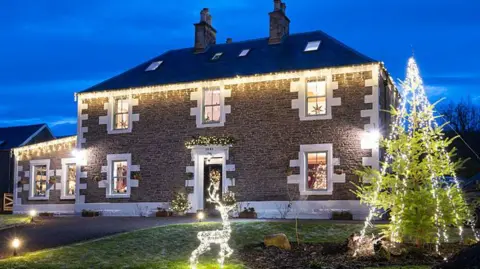 Kirsty Anderson A Victorian house decorated with Christmas lights.