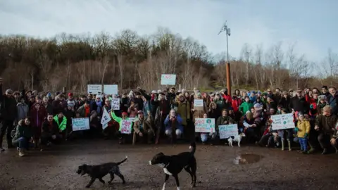 TAL TAKING PICS Protestors holding signs opposing the approval of Westdown Quarry stand together for photo