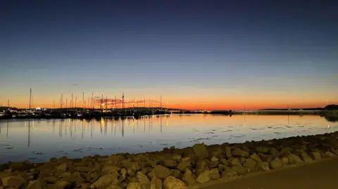 Elaine Cartlidge A sunset glistens over a marina in Orkney