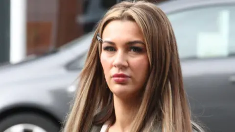 Central Scotland News Agency A woman in her mid-20s with long blonde hair and a black and white top walks outside