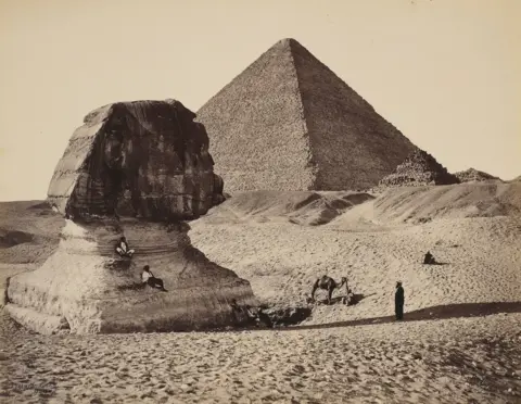 Royal Collection Enterprises Limited 2026 A black and white image of the sphinx and great pyramid at Giza.