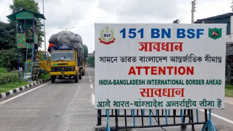 Getty Images Border Security Force (BSF) personnel inspect a truck carrying supplies to Bangladesh at the India-Bangladesh border in Fulbari on the outskirts of Siliguri on August 7, 2024.