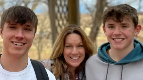 A family picture of Nottingham attacks victim Barnaby Webber, standing next to his mum Emma and brother Charlie. 