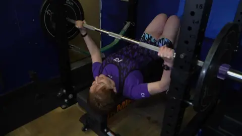 Jackie Mathers lifting weights on a bench