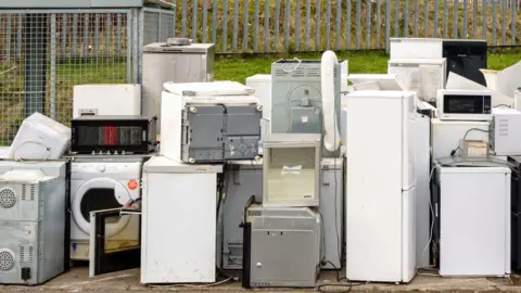 A pile of old fridges, freezers, and other household appliances