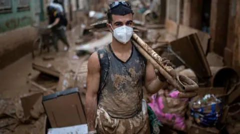 getty Man cleaning up after flood, wearing face mask