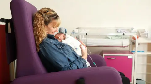  The Royal Wolverhampton NHS Trust New mother Lucy Gould sitting in one of the new chairs with her new-born son