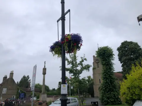 John Devine/BBC Hanging baskets displayed from a lamppost near the parish church in Chatteris