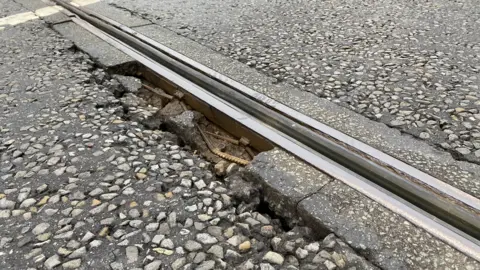 A picture of the damage on the A38, the road is damaged with metal objects spotted. 