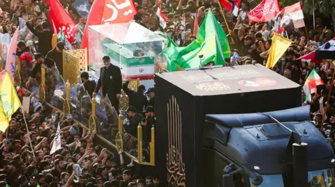 Reuters The coffin of Iran's late Supreme Leader Ayatollah Ali Khamenei is carried by a lorry during a funeral procession in Najaf, Iraq (8 July 2026)