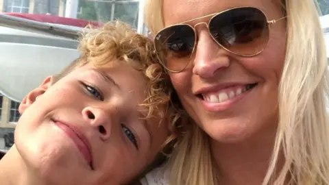 Family Handout A young Mikey Roynon resting his head on his mum Hayley's shoulder