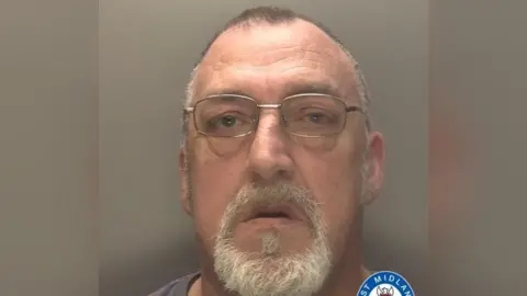 West Midlands Police Mugshot of Clive Penniall looking into the camera wearing square silver glasses