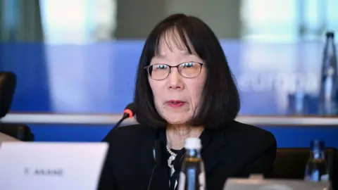 Judge Tomoko Akane at the microphone at an event in Brussels