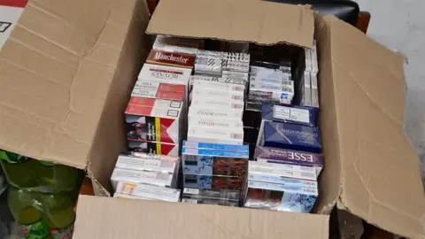 Lincolnshire County Council A cardboard box filled with packets of counterfeit cigarettes