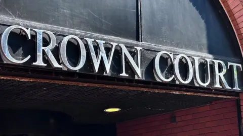Brian Farmer/BBC Cobwebs are visible on the words "crown court" written in silver capital letters over the entrance to a building.