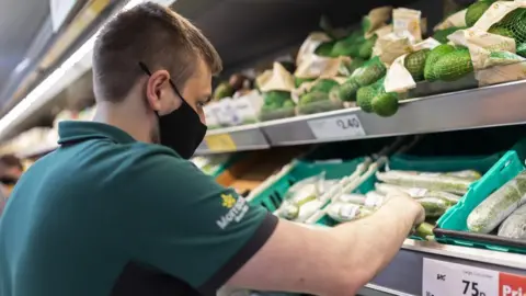 Alamy Man working in a supermarket stocking shelves