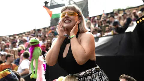 Woman in festival crowd wearing sunglasses